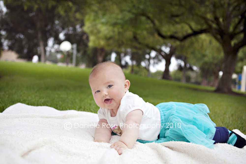 Ventura Child Photographer • Ventura Baby Photorapher A baby smiles during her photo session.